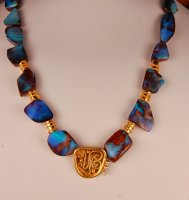 necklace composed of blue opal beads with gold spacers and a gold center piece.